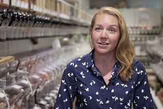 woman standing in the aisle of a in a bulk food shop
