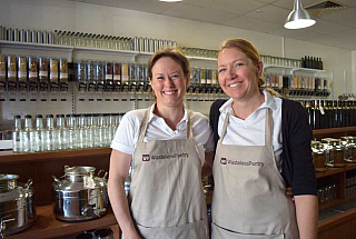 two women with aprons in a bulk food store