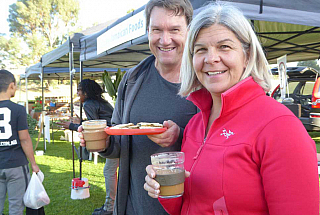 Lucie and her husband with reusable cup and plate at local farmers market